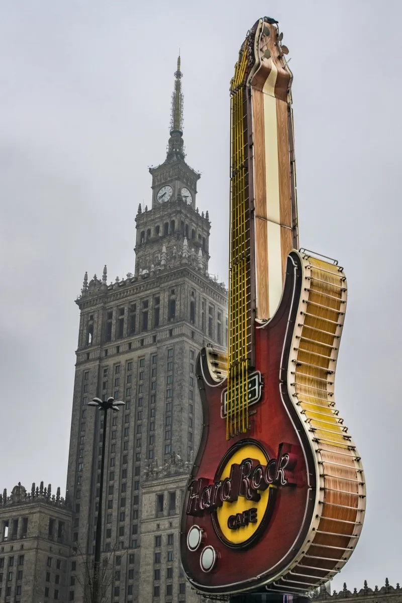 Hard Rock Cafe guitar sign standing in front of the Palace of Culture and Science